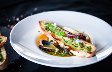 tasty seafood soup with fresh vegetables - shrimps, shells, octopus and crispy home made bread