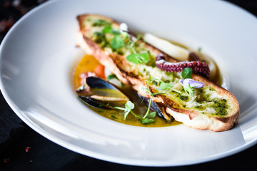 tasty seafood soup with fresh vegetables - shrimps, shells, octopus and crispy home made bread