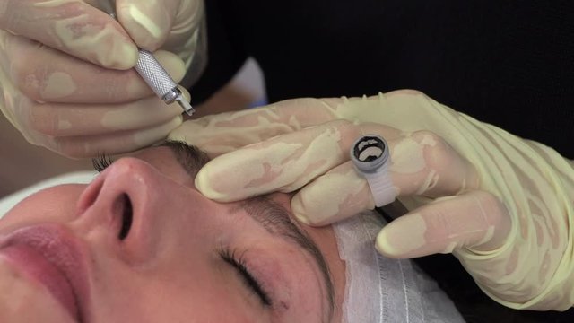 Young girl make permanent makeup. Eyebrow Microblading