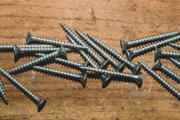 Screws on a wooden background.working tools