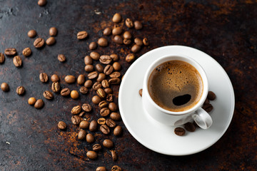 White espresso coffee Cup and coffee beans on rusty dark background
