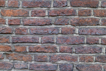 very old uneven dark brown brick wall