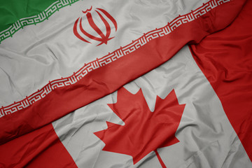 waving colorful flag of canada and national flag of iran.