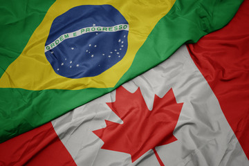 waving colorful flag of canada and national flag of brazil.