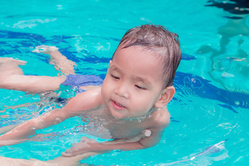 Fototapeta na wymiar asian children having fun in a swimming pool at thailand