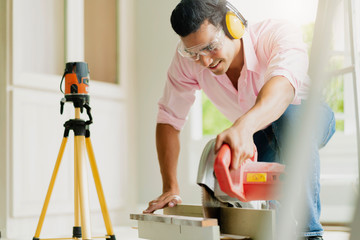 smart indian contractor hand use sawing machine wood work house renovation background home...
