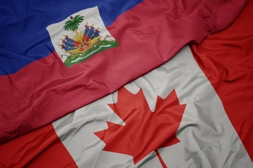 waving colorful flag of canada and national flag of haiti.
