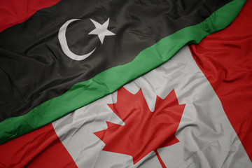 waving colorful flag of canada and national flag of libya.