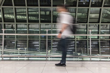 Obraz premium A man walking in blurred motion at airport hall. Abstract image of traveler in the lobby.