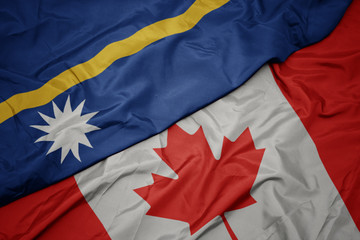 waving colorful flag of canada and national flag of Nauru.