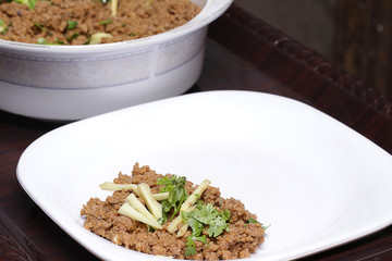 A spicy beef keema (mince) on a plate traditionally served with someone.