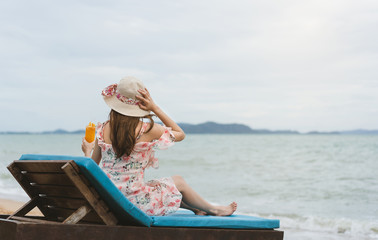 Relax young woman with hat drinking refresh orange cocktail