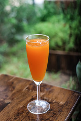 fresh orange juice on chair wooden and grass green background