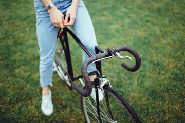 Fototapeta na wymiar Pretty woman using cycling on the street,outdoor fashion portrait,hipster style ,sunglasses, sneakers,outdoor woman portrait on bike cycle,happy face,close up.spring, sunglasses fashion,cute,emotional