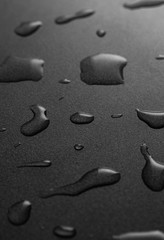 Fototapeta na wymiar Water drops on the black surface