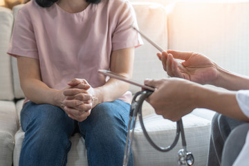 Doctor or psychiatrist consulting and diagnostic examining stressful woman patient on obstetric -...