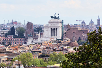 Fototapeta na wymiar A look to Rome and its urban architectural beauties with the profile of the monumental altar of the homeland, historic buildings and ancient houses and many domes of churches