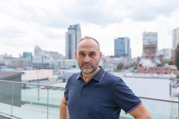 Portrait of a mature man on a city street background.