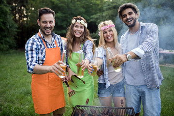 Fototapeta premium Happy group of friends making a barbecue together outdoors in the nature