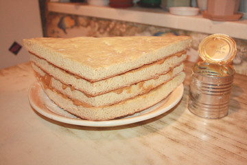 Homemade  triangular cake during preparation on a saucer in the kitchen