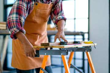 Craftsman set up the instrument for wood cutting in the working room.