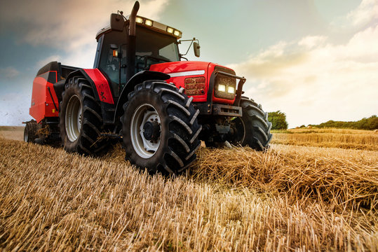 farmer in fields making straw bales