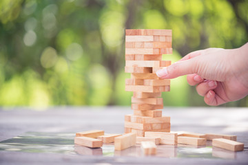 Closeup of asian woman's hand playing wood blocks stack game. Education and development concept.