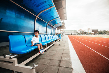 baby boy sitting on chair in stadium and track © Eaknarin