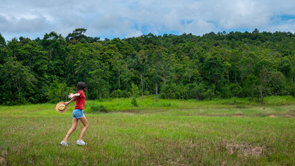 Young asia woman in a green field,enjoying in the sunny summer day.