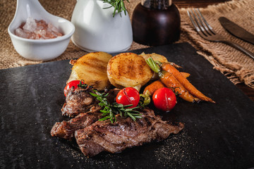 Beef steak with vegetables and spices on a cutting board
