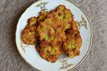 Potato pancakes with sausage on a ceramic plate.