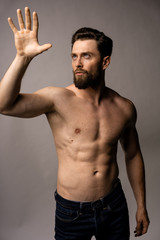 Fototapeta premium Man in the jeans wave hi to somebody. Topless model, strong view. Handsome man.