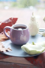  Cup of tea on the background of the window, behind which rain, pumpkins, a warm scarf, leaves, autumn season, the concept of home comfort