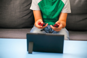 Kid with two gamepads playing video game console