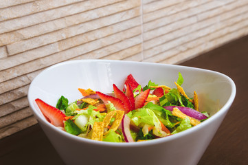 Fresh Summer Salad with Strawberries in a Wide Bowl closeup