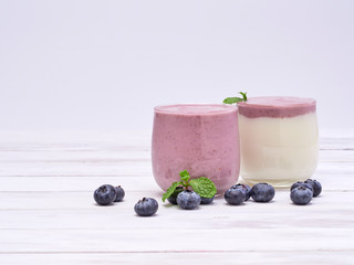 White yogurt and blueberry yogurt on wooden table