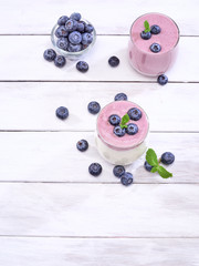Naklejka na ściany i meble White yogurt and blueberry yogurt on wooden table