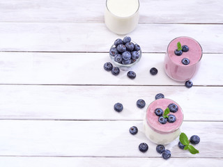Fototapeta na wymiar Blueberry yogurt and white yogurt on wooden table