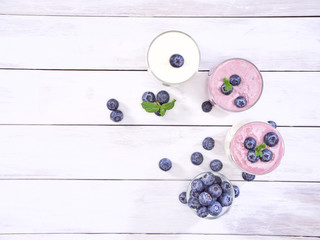 Blueberry yogurt and white yogurt on wooden table