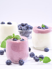 Blueberry yogurt and white yogurt on wooden table