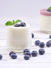 White yogurt and blueberry yogurt on wooden table