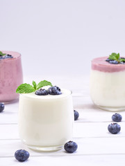 Blueberry yogurt and white yogurt on wooden table