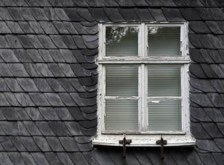 Altes Schieferhaus mit defekten Holzfenster