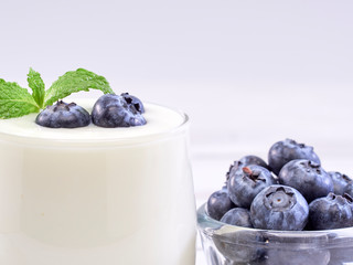 Blueberry yogurt glass on white wooden table