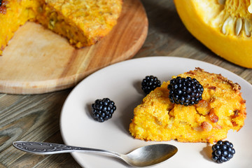 Homemade fresh round bright orange sliced pumpkin tart pie recipe with raisins on rustic wood background. Pumpkin Pie decorated for Halloween. Celebrating Thanksgiving Holiday Tradition Concept