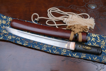 The traditional Japanese weapon is the samurai sword of katana and sheath on the table.