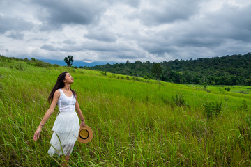 Girl with white dress in a green field,enjoying in the sunny summer day