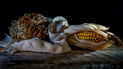 verwelkte Rosen und ein vertrockneter Maiskolben