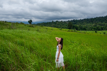 Girl with white dress in a green field,enjoying in the sunny summer day