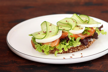 Smoked salmon toast with cream cheese, lettuce, cucumber and egg for breakfast